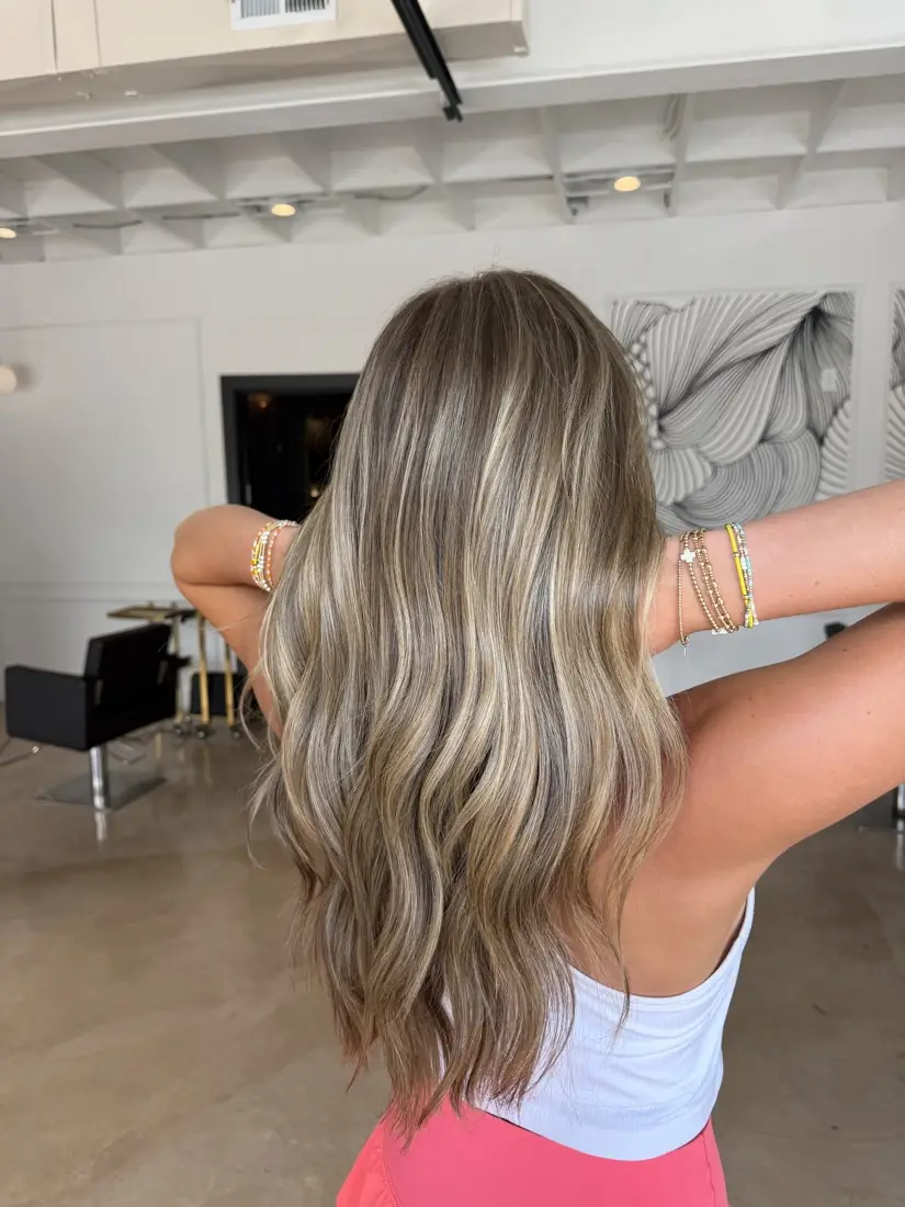 Dimensional blonde balayage seen from behind in the salon.