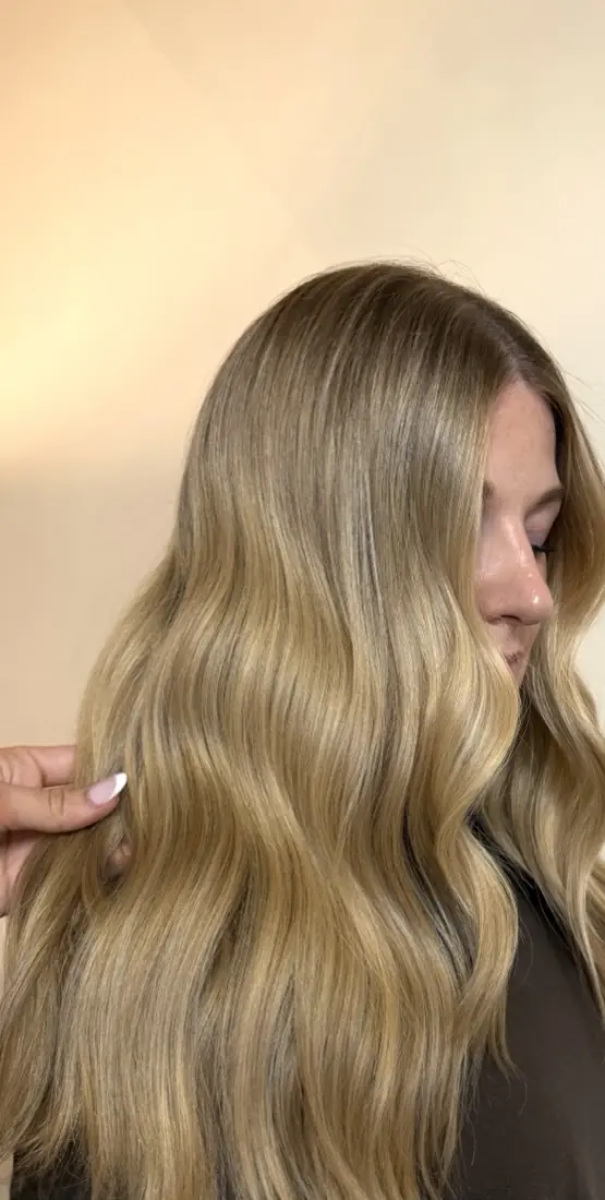 Warm golden blonde waves against a cream backdrop.