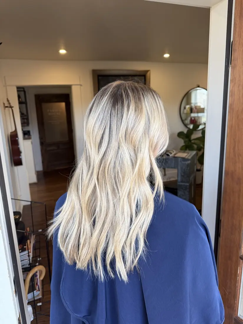 Bright blonde balayage at mid-length, softly finished.
