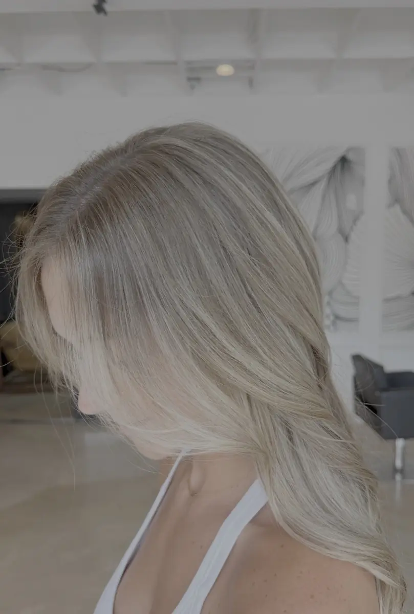 Cool ash blonde worn long, seen in side profile.